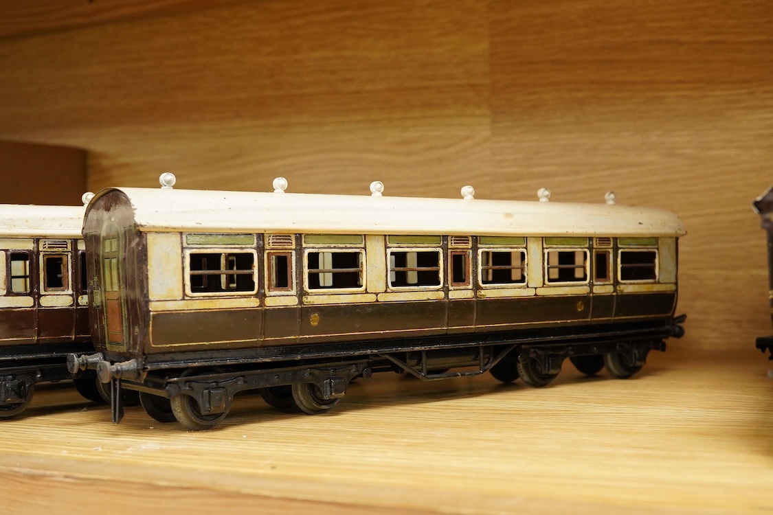 Five 0 gauge tinplate LNWR bogie coaches; four Bing for Bassett-Lowke 1921 series coaches; three Full First corridor coaches, and a Brake Third, together with a Carette 12-wheel Dining Saloon, 13210, all in chocolate and